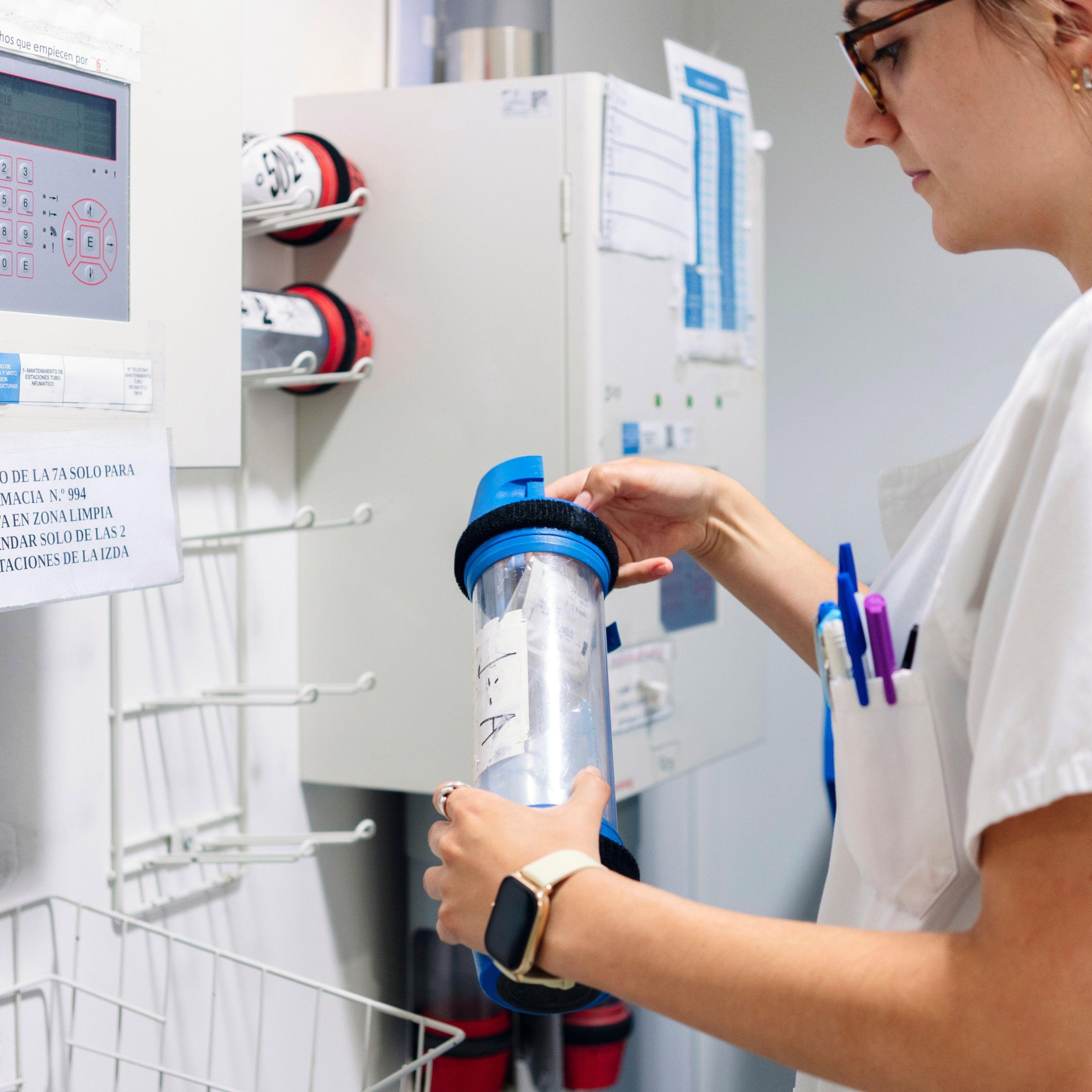 Doctor holding pneumatic tube carrier while standing in pharmacy