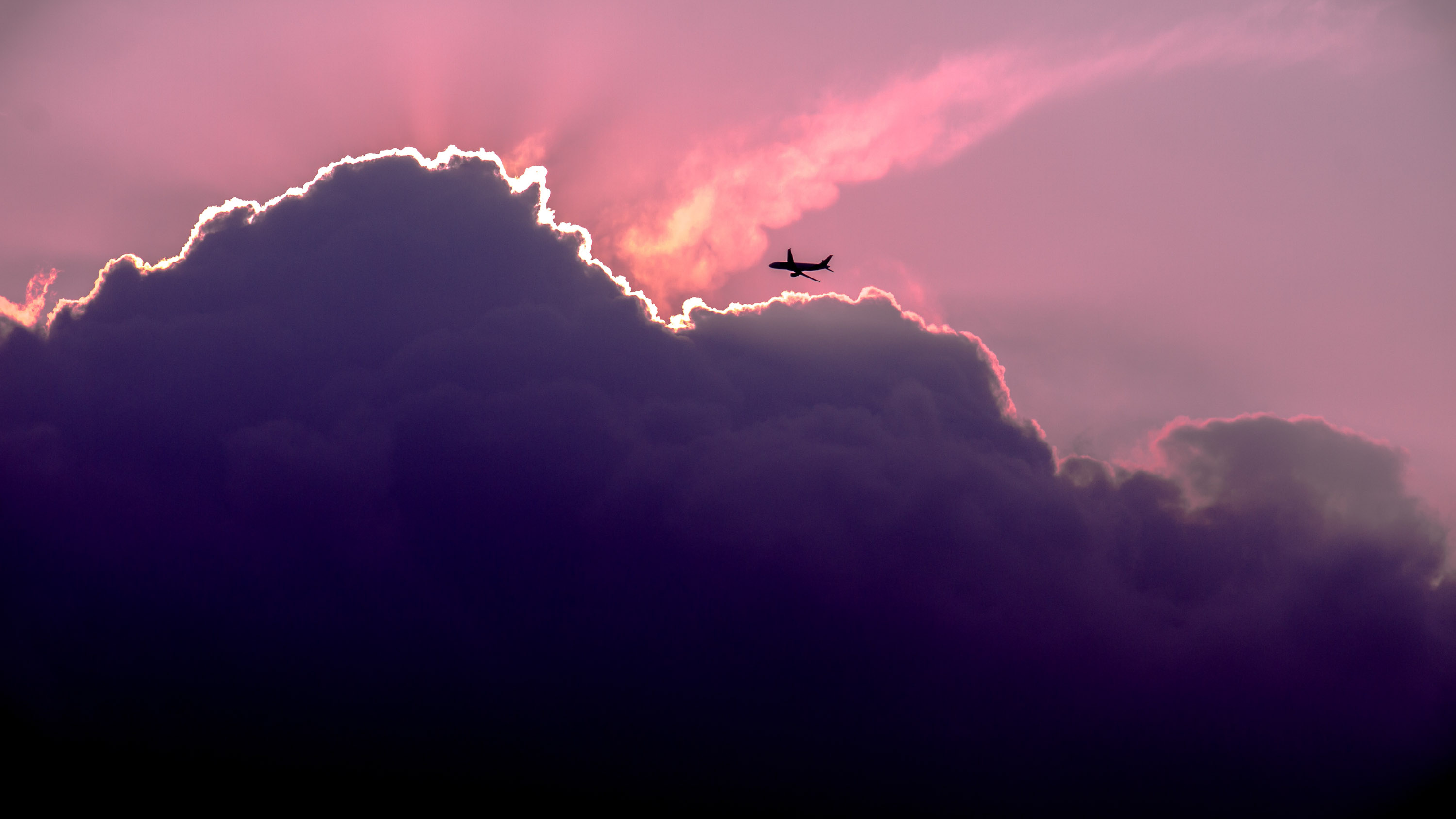 A plane flies near clouds.